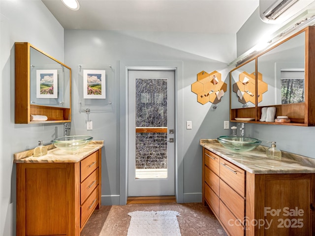 bathroom with two vanities, a sink, and a wall mounted AC