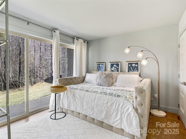 bedroom featuring baseboards, multiple windows, and access to exterior