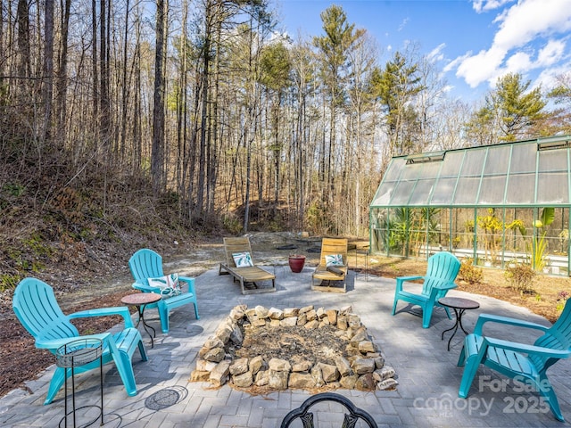 view of patio featuring an outbuilding and a greenhouse