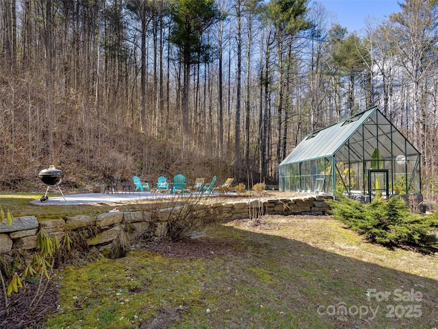 view of yard with an outbuilding and a greenhouse