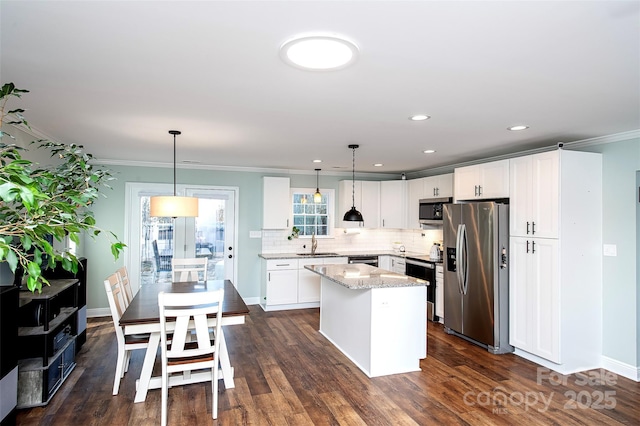 kitchen featuring white cabinetry, pendant lighting, stainless steel appliances, and a center island