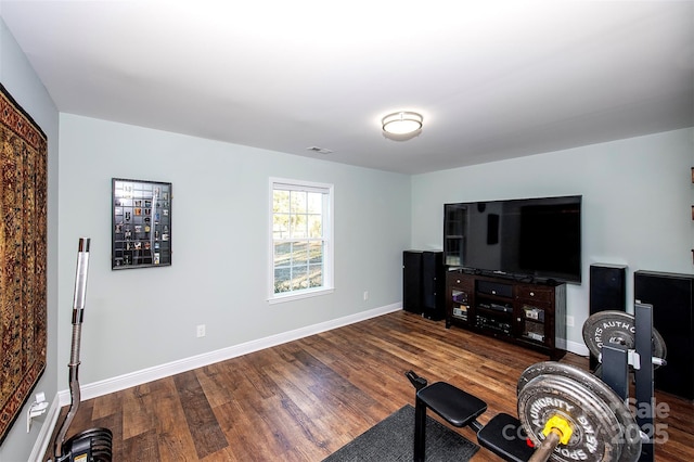 living room with wood finished floors, visible vents, and baseboards