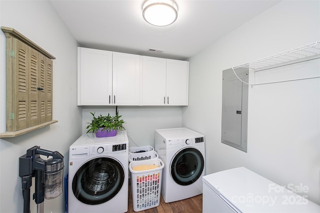 laundry room with washer and dryer, electric panel, cabinet space, and dark wood-style flooring