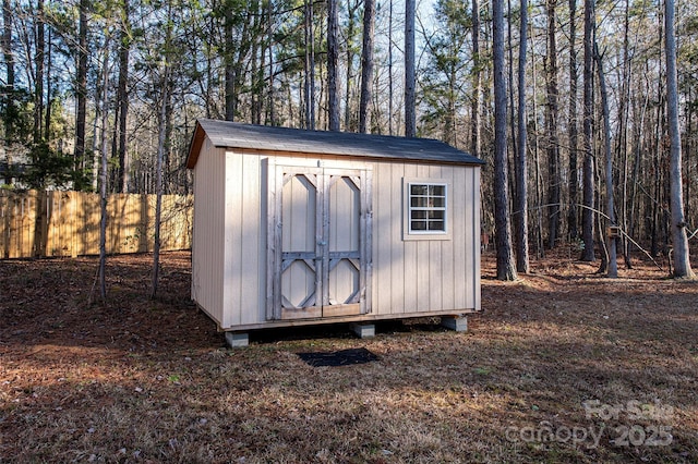 view of shed featuring fence