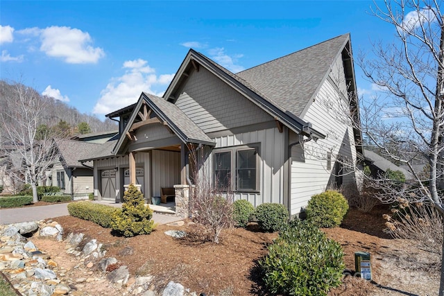 view of front of home with a garage, roof with shingles, a porch, and board and batten siding