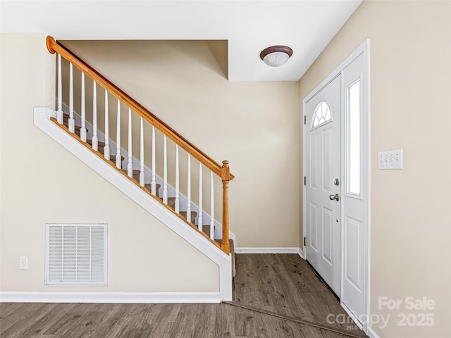 entrance foyer featuring dark wood-type flooring, visible vents, baseboards, and stairs