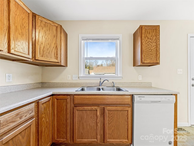 kitchen featuring dishwasher, light countertops, brown cabinetry, and a sink