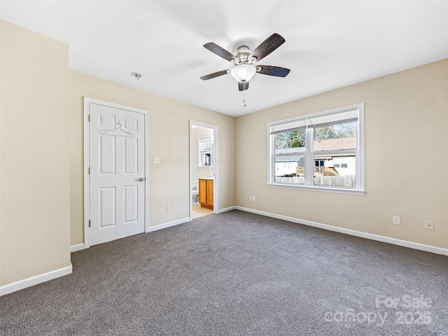 unfurnished bedroom with carpet floors, baseboards, a ceiling fan, and ensuite bathroom