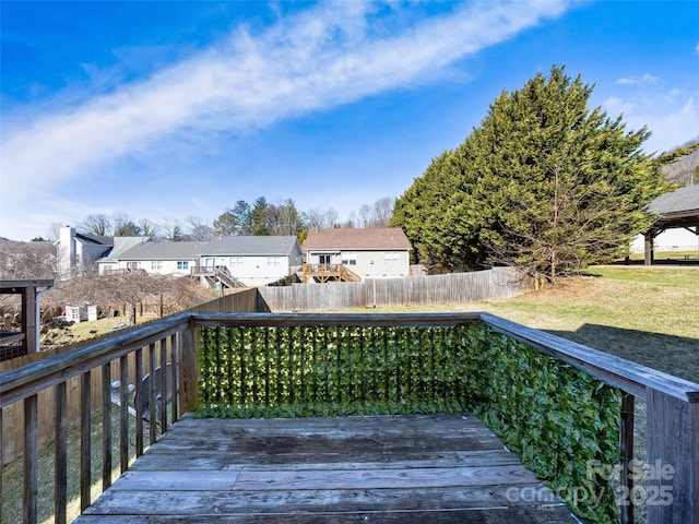 wooden terrace featuring a residential view and fence