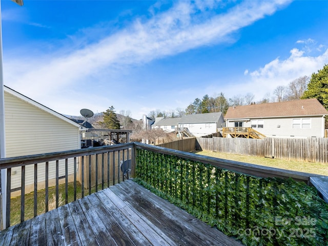 wooden terrace featuring a residential view and a fenced backyard