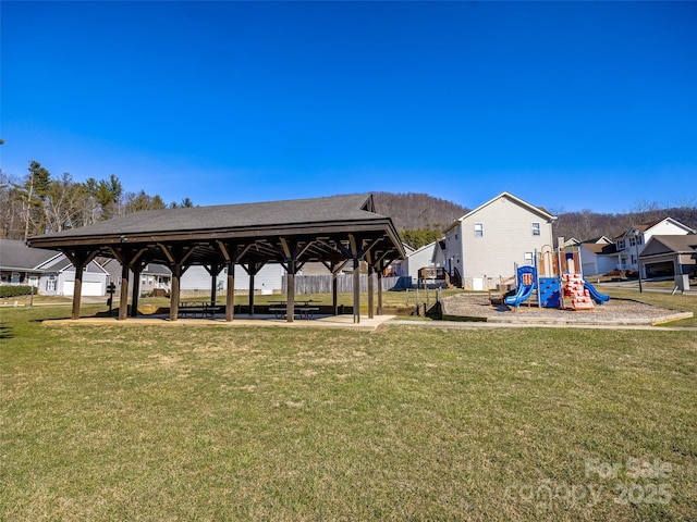 surrounding community with playground community and a lawn