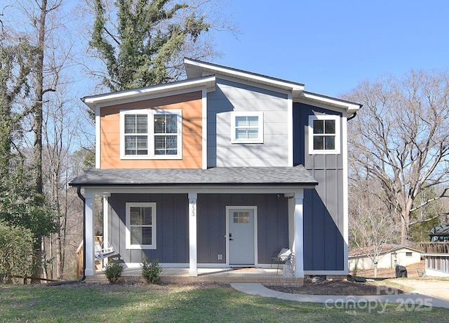 view of front facade with covered porch, board and batten siding, and roof with shingles