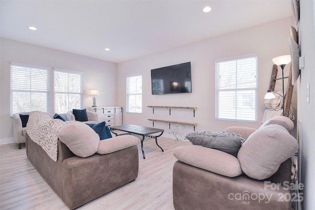 living room featuring light wood-type flooring, baseboards, and recessed lighting