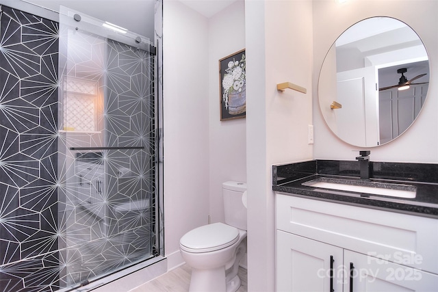 full bath with a shower stall, vanity, and toilet