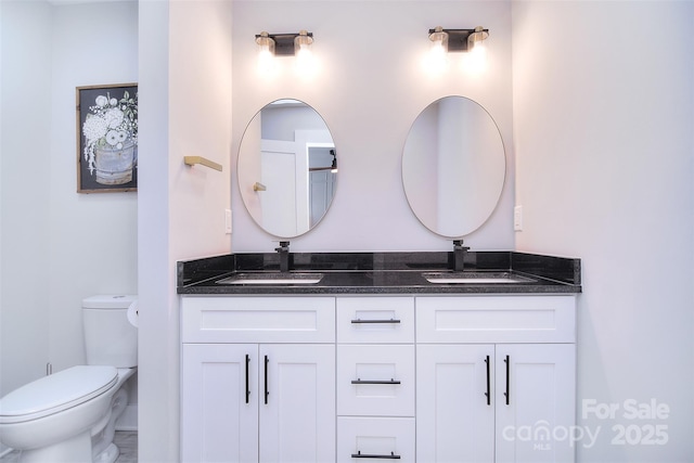 bathroom featuring a sink, toilet, and double vanity