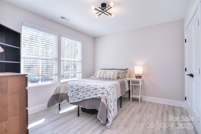 bedroom featuring multiple windows, visible vents, and light wood-style floors