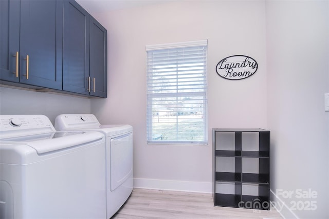 clothes washing area with separate washer and dryer, light wood-style flooring, cabinet space, and a healthy amount of sunlight