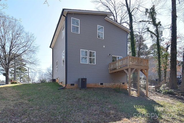 rear view of property with crawl space, central air condition unit, a wooden deck, and a yard