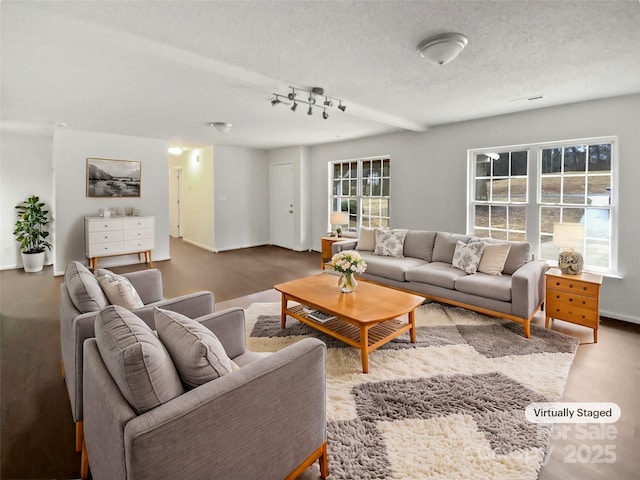 living room with a textured ceiling and baseboards