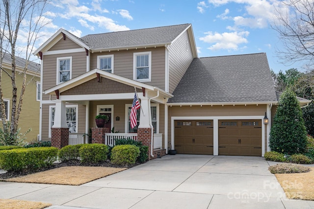 craftsman-style home featuring concrete driveway, a porch, roof with shingles, and an attached garage