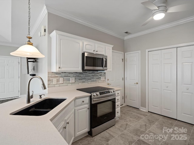 kitchen with pendant lighting, stainless steel appliances, ornamental molding, white cabinetry, and a sink