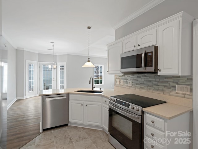 kitchen with appliances with stainless steel finishes, white cabinetry, a sink, and a peninsula