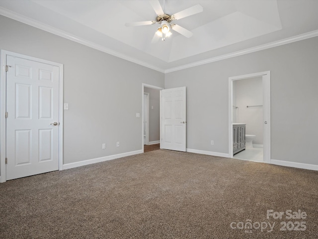 unfurnished bedroom featuring carpet floors, baseboards, ornamental molding, and a raised ceiling