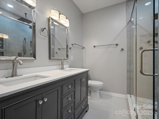 bathroom featuring double vanity, a sink, and a shower stall