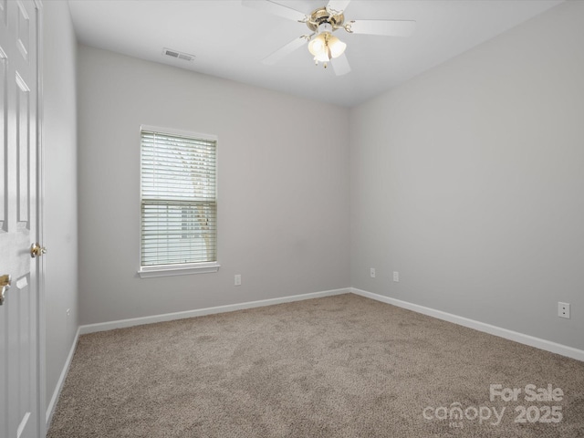 spare room with baseboards, carpet, visible vents, and a ceiling fan