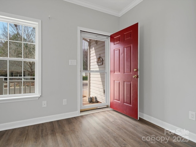 foyer entrance featuring ornamental molding, wood finished floors, and baseboards