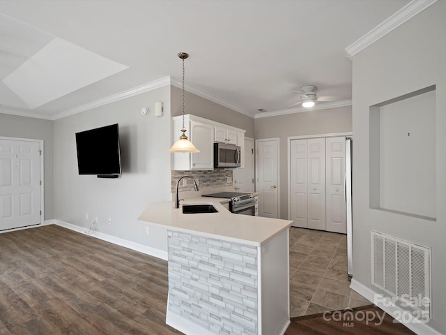 kitchen with visible vents, white cabinets, appliances with stainless steel finishes, light countertops, and a sink