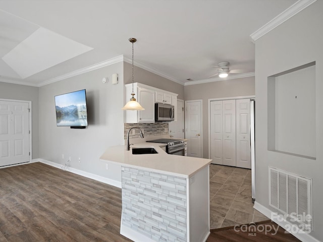 kitchen with visible vents, appliances with stainless steel finishes, light countertops, white cabinetry, and a sink