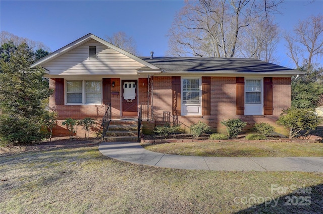 single story home featuring a front yard and brick siding