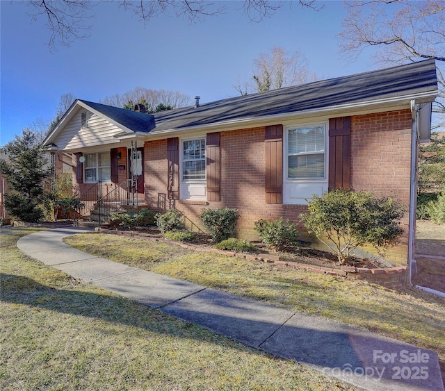 ranch-style home featuring a front yard and brick siding