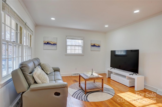 living room featuring visible vents, crown molding, light wood-style flooring, and baseboards