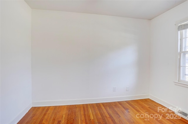 spare room with wood finished floors and baseboards