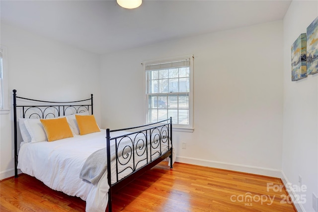 bedroom featuring wood finished floors and baseboards