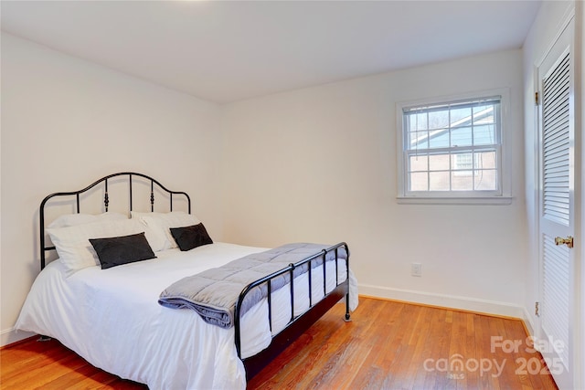 bedroom featuring baseboards and wood finished floors