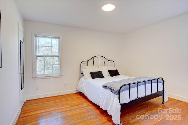 bedroom featuring wood finished floors and baseboards