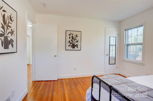 unfurnished bedroom featuring baseboards, visible vents, and light wood-style floors