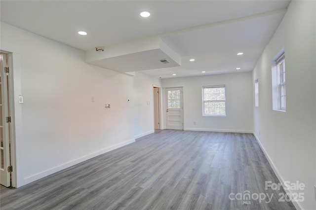 spare room with baseboards, wood finished floors, and recessed lighting