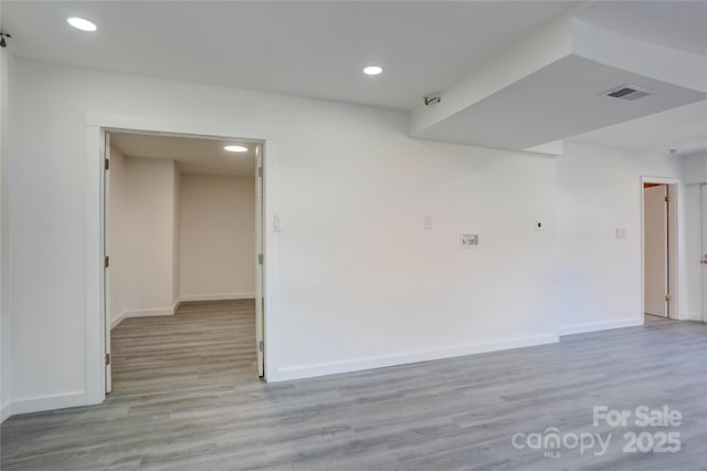 spare room with light wood-type flooring, baseboards, and visible vents