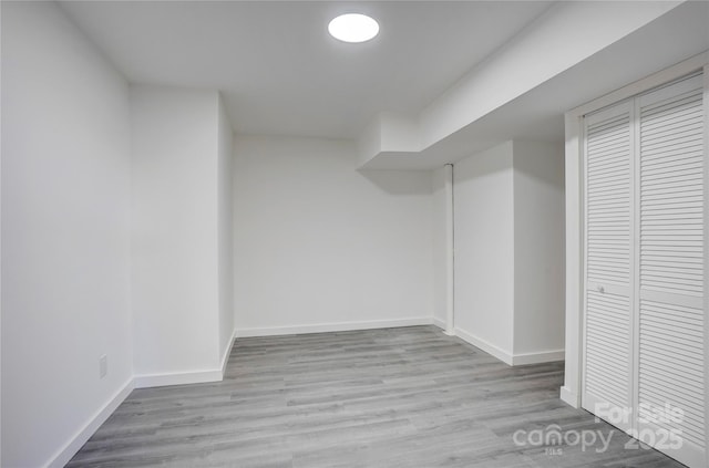 finished basement with light wood-type flooring and baseboards