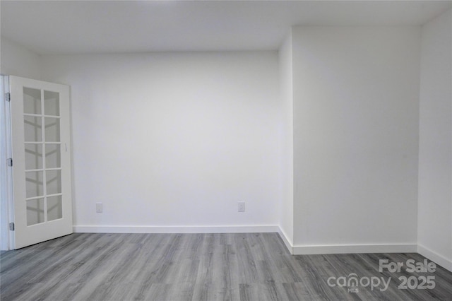 spare room with light wood-style floors and baseboards