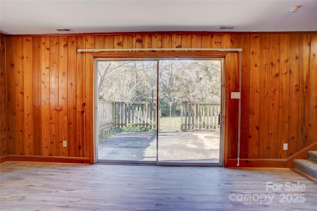 doorway with light wood finished floors, stairs, and a wealth of natural light