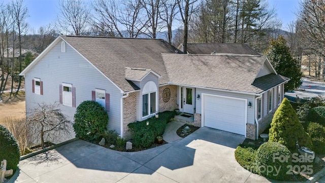 view of front of home with an attached garage, brick siding, concrete driveway, and roof with shingles