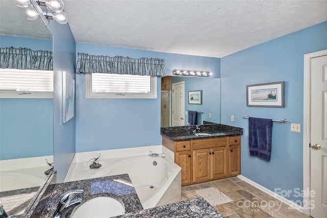 full bathroom with a shower stall, a garden tub, vanity, and a textured ceiling