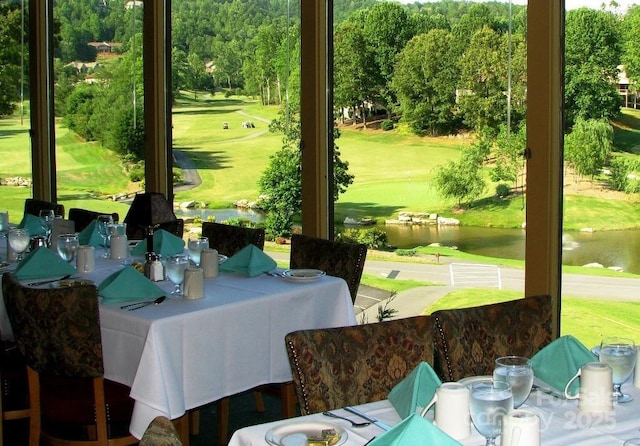 sunroom with a water view and view of golf course