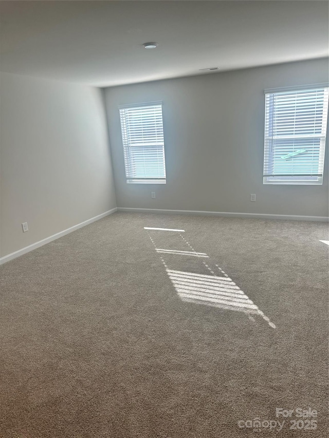 spare room featuring a healthy amount of sunlight and baseboards