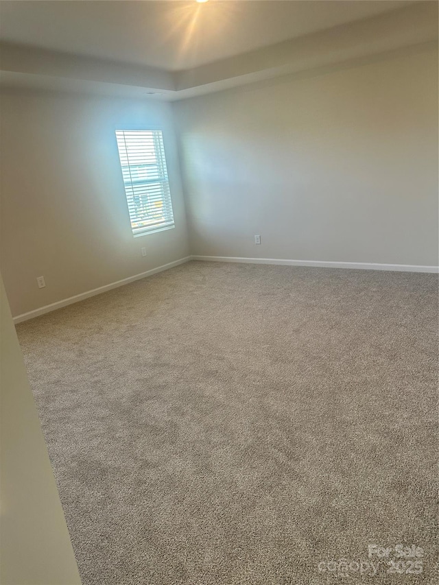 carpeted empty room with baseboards